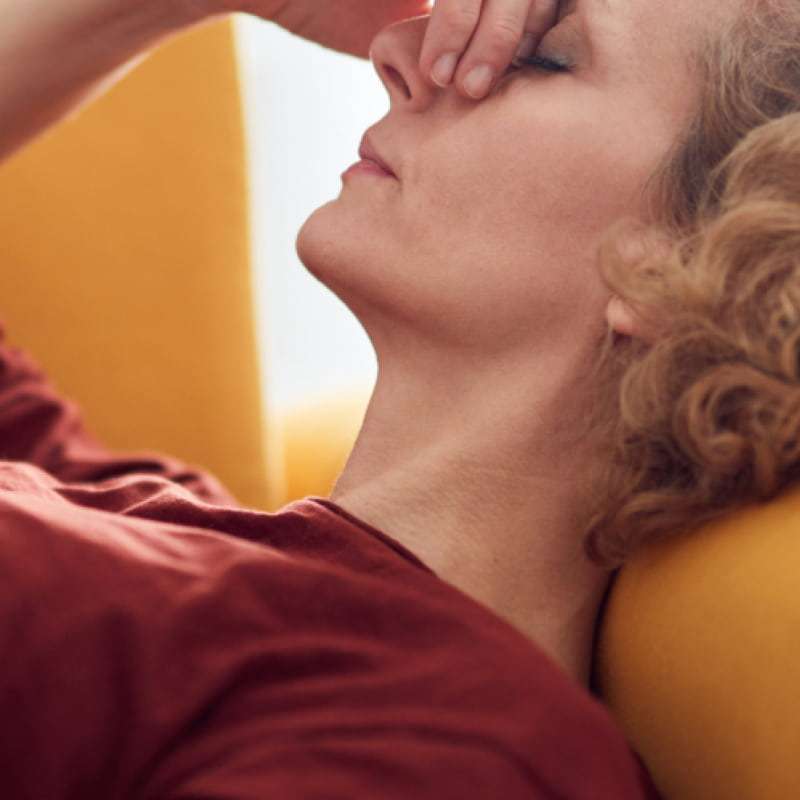Lady suffering from acid reflux, wondering the difference between Omeprazole and Lansoprazole