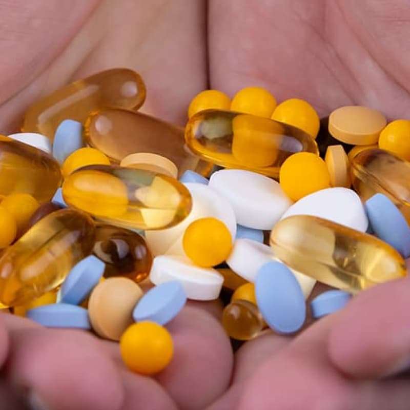 Hand holding multiple tablets, e-Surgery's campaign against counterfeit medication ED
